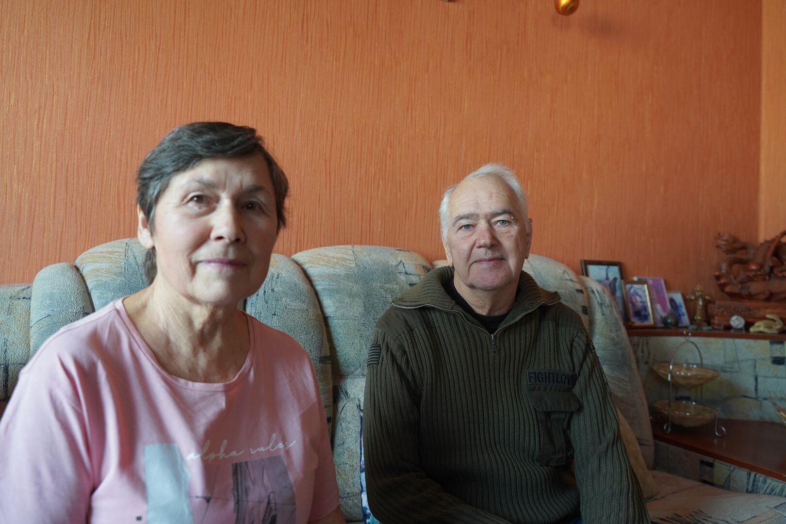 Olena and Kostiantyn sit inside their apartment in Kharkiv, Ukraine, where UNHCR repairs helped make their home warmer and safer during winter.