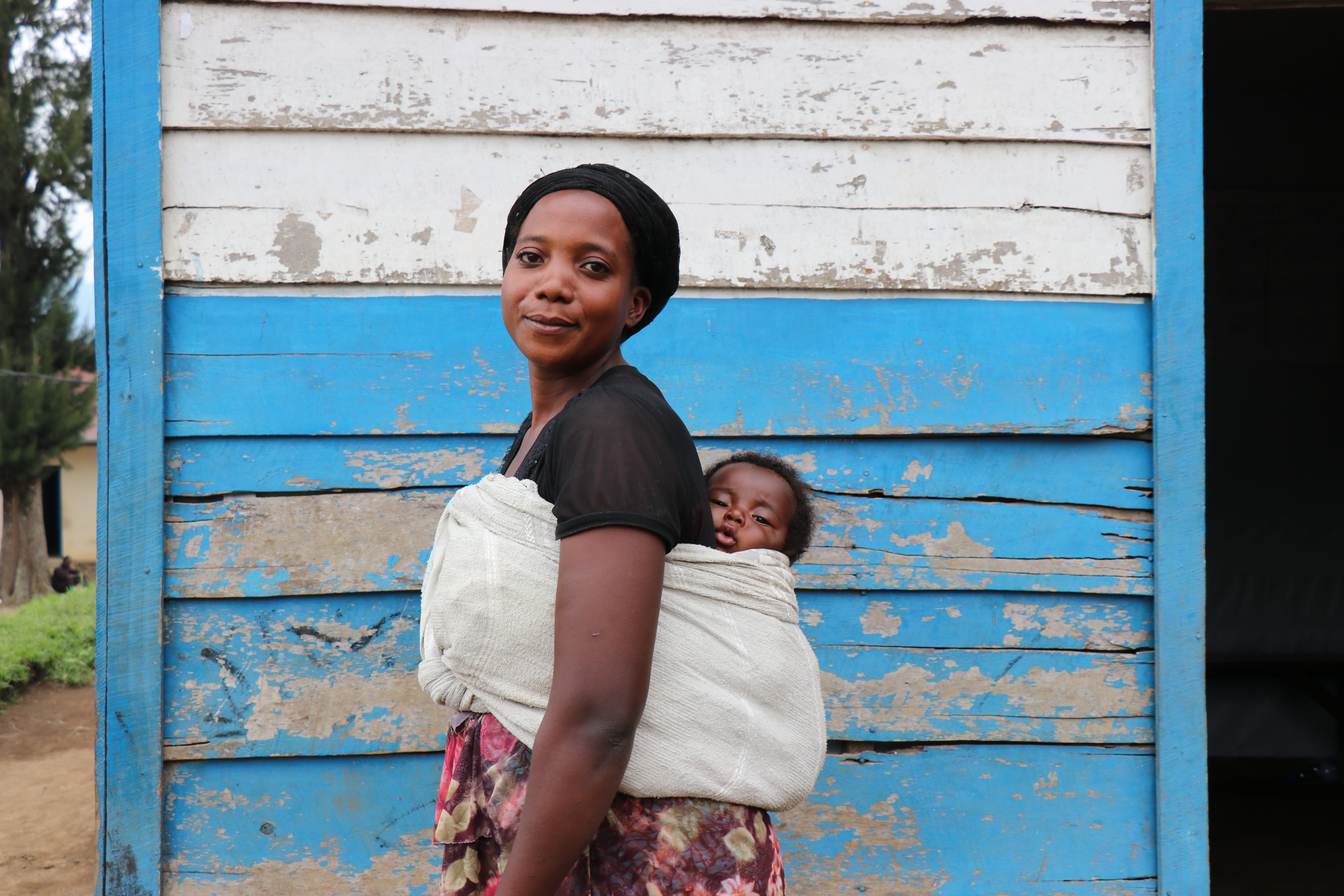 Displaced woman holds baby. In Masisi, Democratic Republic of Congo, UNHCR empowers women to become leaders in their communities 