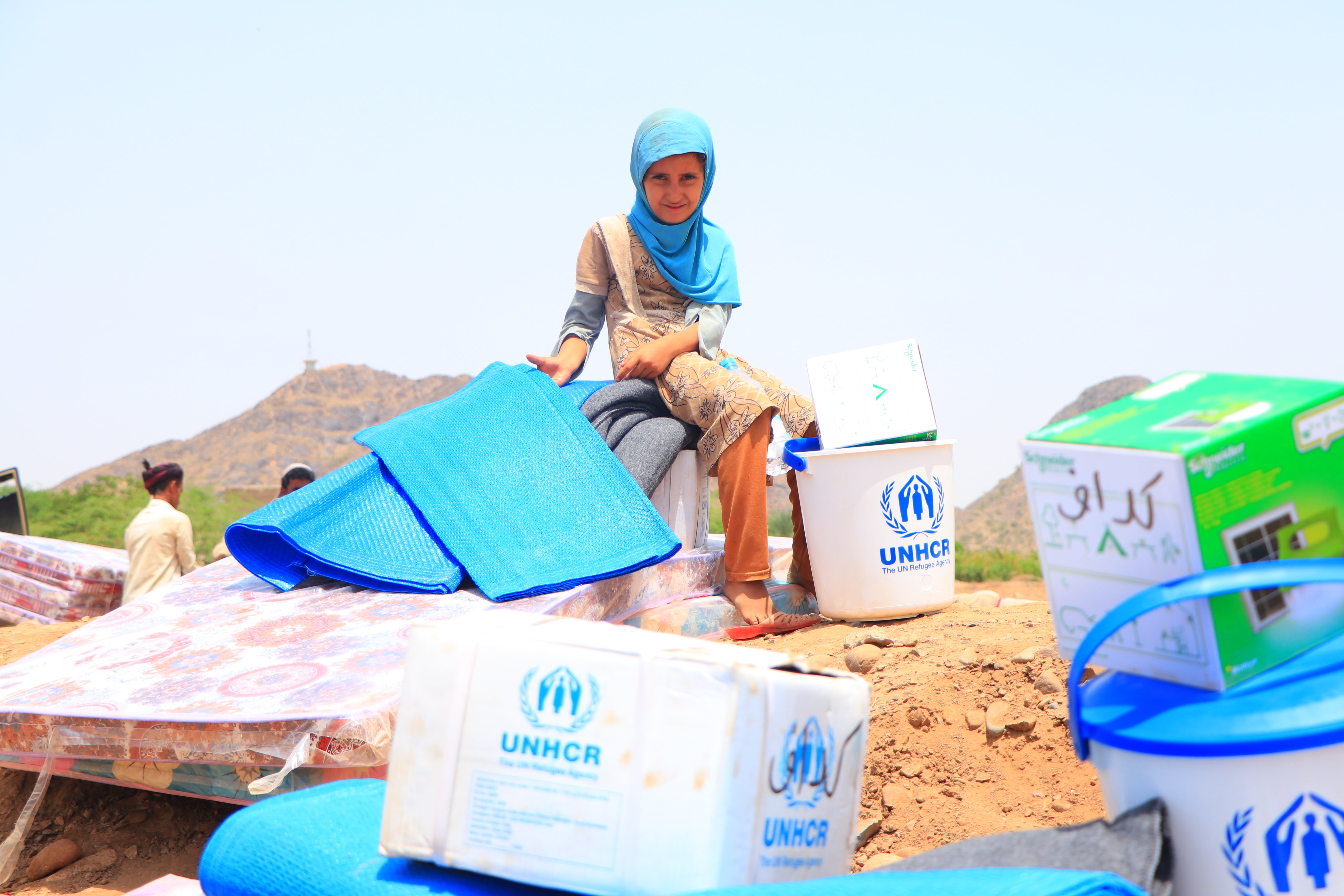 Child with UNHCR supplies. Displaced families in Yemen receive essential household items.